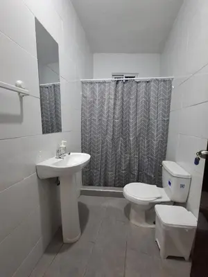 a white bathroom with a toilet and a sink at Doña Minda Home in Naiboa