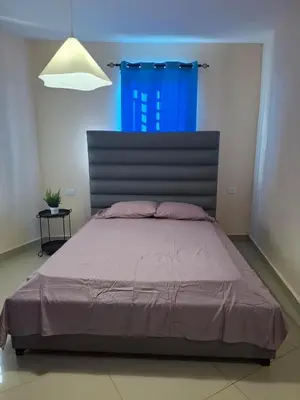 a bedroom with a large bed with a blue window at Doña Minda Home in Naiboa