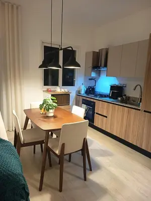 a kitchen with a wooden table and chairs and a dining room at Cozy tiny home by the beach in La Laguna