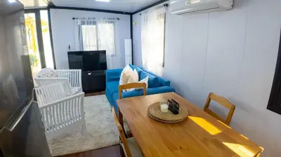a living room with a table and a blue couch at Cozy tiny home by the beach in La Laguna