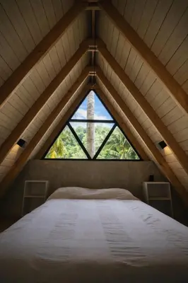 a bed in a room with a large window at Casa Cayena - Hibiscus House in El Valle
