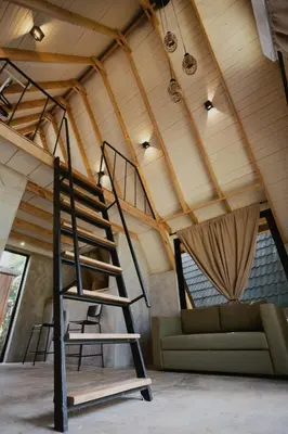 a loft conversion with a spiral staircase and a couch at Casa Cayena - Hibiscus House in El Valle