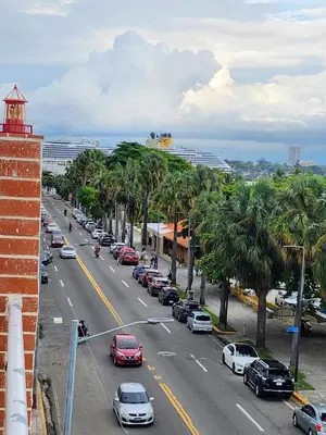 a street with cars parked on a street with palm trees at Hotel La Llave Del Mar in Santo Domingo