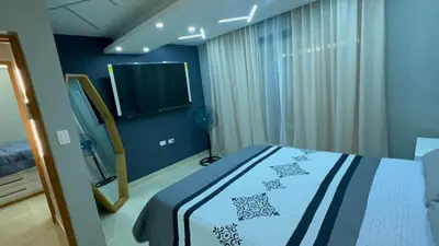 a bedroom with a bed and a television in it at D Gomez House in Santiago de los Caballeros