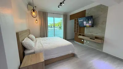 a bedroom with a bed and a flat screen tv at Hotel Juan Dolio in Juan Dolio