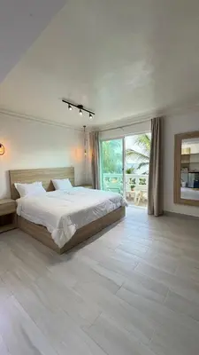 a bedroom with a large bed and a large window at Hotel Juan Dolio in Juan Dolio