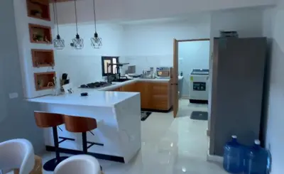 a kitchen with a counter and chairs in a room at Dgomez House in Santiago de los Caballeros