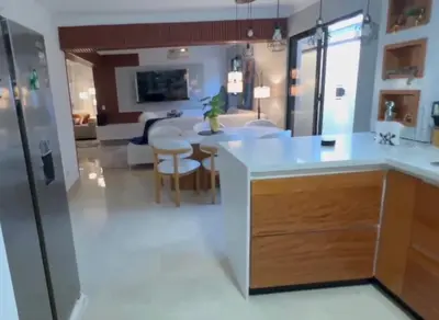 a kitchen with white countertops and a living room at Dgomez House in Santiago de los Caballeros