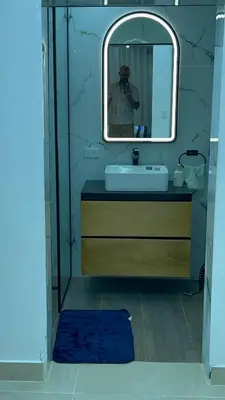 a man taking a picture of a bathroom with a mirror at Dgomez House in Santiago de los Caballeros