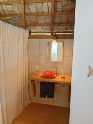 a bathroom with a sink and a bowl of fruit on a table at Mejor, Quédate Aquí in Las Galeras