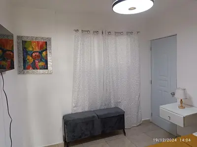 a white room with a shower curtain and a table at Casa de Huésped Romana in La Romana