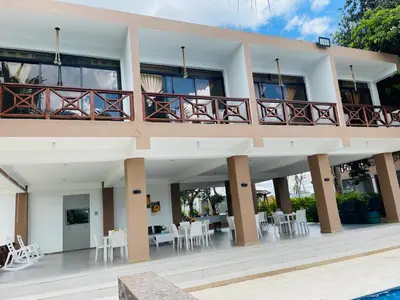 a building with a balcony with tables and chairs at Rancho Paraíso Escondido