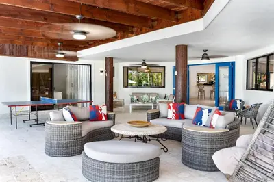 a living room with wicker furniture and a pool table at Villa Reme 19 in La Romana