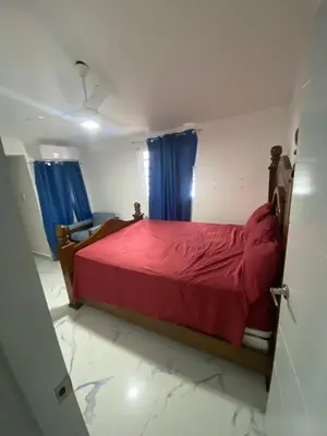 a bedroom with a red bed with blue curtains at Brisas del mar in San Felipe de Puerto Plata