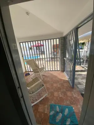 a porch with a rocking chair and a balcony at Brisas del mar in San Felipe de Puerto Plata