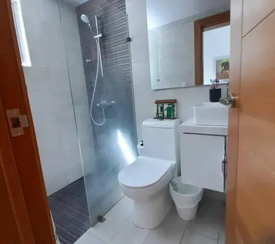 a bathroom with a toilet and a glass shower at Luxury 3-Bedroom Apartment with Pool in Naco, Santo Domingo in Santo Domingo