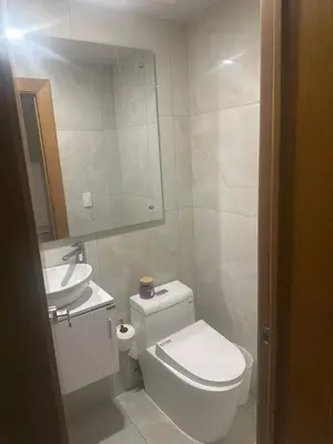 a white bathroom with a toilet and a sink at Luxury 3-Bedroom Apartment with Pool in Naco, Santo Domingo in Santo Domingo