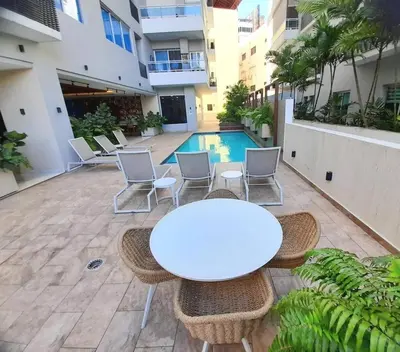 a patio with a table and chairs and a pool at Luxury 3-Bedroom Apartment with Pool in Naco, Santo Domingo in Santo Domingo