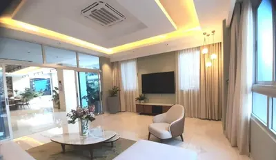 a living room with a television and a table and chairs at Luxury 3-Bedroom Apartment with Pool in Naco, Santo Domingo in Santo Domingo