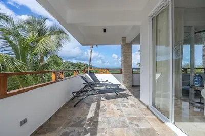 a balcony with chairs and a view of the ocean at Private Rooftop Penthouse Near Coson Beach Jacuzzi and BBQ in Las Terrenas