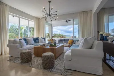 a living room with white furniture and large windows at Private Rooftop Penthouse Near Coson Beach Jacuzzi and BBQ in Las Terrenas