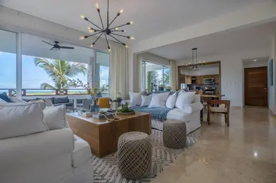 a living room with white couches and a dining room at Private Rooftop Penthouse Near Coson Beach Jacuzzi and BBQ in Las Terrenas