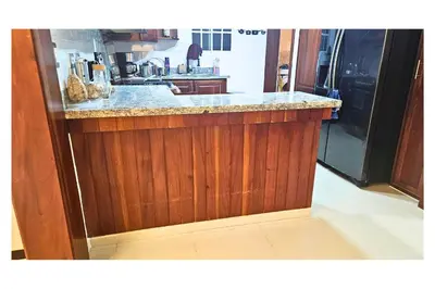 a kitchen with a wooden counter with a refrigerator at Cubana Stays in Santiago de los Caballeros