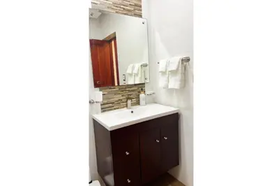 a bathroom with a sink and a mirror at Cubana Stays in Santiago de los Caballeros