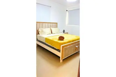 a bedroom with a bed with a cat sitting on it at Cubana Stays in Santiago de los Caballeros