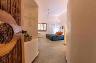 a room with a bedroom with a bed and a door at 5BR Serendipity Pool Ocean View Jungle in Las Terrenas