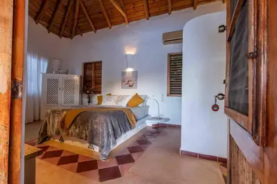 a bedroom with a bed and a checkered floor at 5BR Serendipity Pool Ocean View Jungle in Las Terrenas