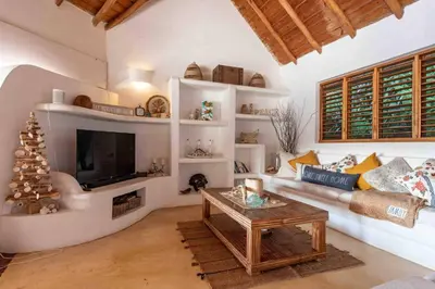 a living room with a couch and a tv at 5BR Serendipity Pool Ocean View Jungle in Las Terrenas