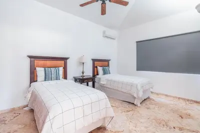 a bedroom with two beds and a ceiling fan at Comfortable villa with garden view and 3 bedrooms in Cajuiles