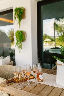 a wooden table with wine glasses on it at Aqua Luxe Opulence Vista Piscina & Golf · by Sun5 in Punta Cana