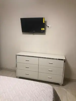 a bedroom with a dresser with a tv on the wall at Apartamento acogedor en Santo Domingo este in Hainamosa