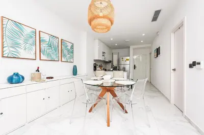 a kitchen with white cabinets and a table and chairs at Luxury 2BR, Private Jacuzzi, CanaRock Star in Punta Cana