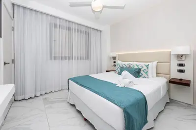 a white bedroom with a large bed and a window at Luxury 2BR, Private Jacuzzi, CanaRock Star in Punta Cana