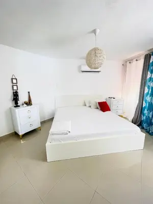a white bedroom with a bed and a pendant light at vista paraiso del mar in Villas del Mar