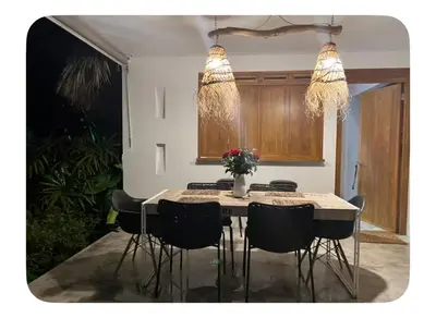 a dining room table with black chairs and two lights at Villa Leon Azul in La Iglesia