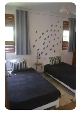 a bedroom with two beds and a wall with birds on it at Villa Leon Azul in La Iglesia