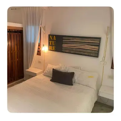 a white bed with a black pillow on top of it at Villa Leon Azul in La Iglesia