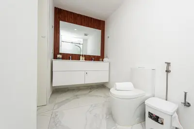 a white bathroom with a sink and a toilet at Luxury 2BR Private Jacuzzi CanaRock Star Punta Cana in Punta Cana