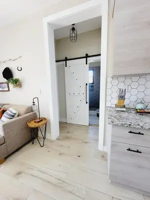 a living room with a couch and a pivot door at Encuentro Vaquero in Jarabacoa