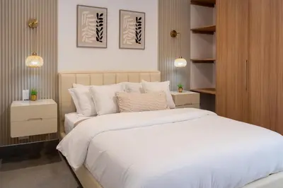 a bedroom with a large bed with white sheets at Playa Bonita Fully Serviced Villa - Walk to Beach in Las Terrenas