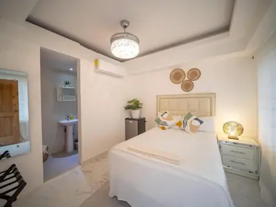 a white bedroom with a large white bed and a sink at Room in Sosua center with Outdoor Jacuzzi in Sosúa