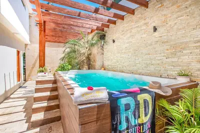 a swimming pool in a room with a brick wall at Room in Sosua center with Outdoor Jacuzzi in Sosúa