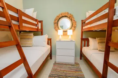 a bedroom with two bunk beds and a mirror at Stunning Beachfront 2BR Condo in Juan Dolio in Juan Dolio