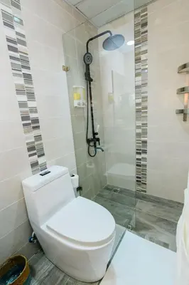 a bathroom with a white toilet and a shower at Stunning Beachfront 2BR Condo in Juan Dolio in Juan Dolio