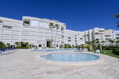 a large building with a swimming pool in front of it at Stunning Beachfront 2BR Condo in Juan Dolio in Juan Dolio