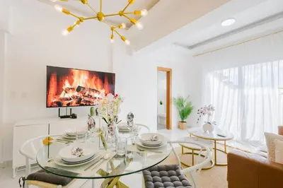 a dining room with a glass table and a fireplace at Cozy 3BR Condo in Ens. Ozama in La Cruz de Mendoza
